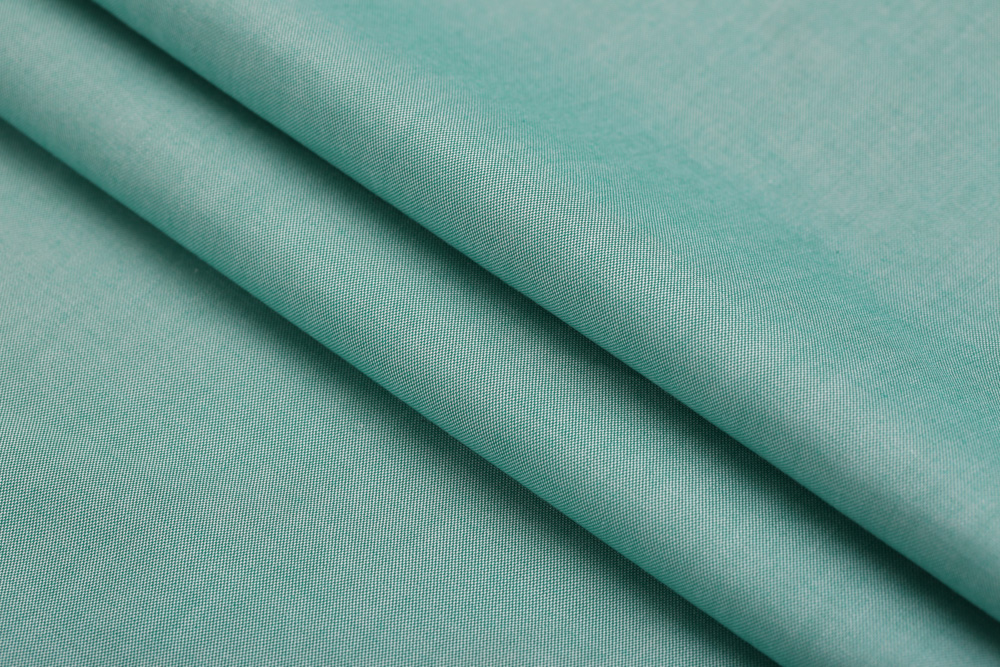 Soft green textured fabric with folded layers